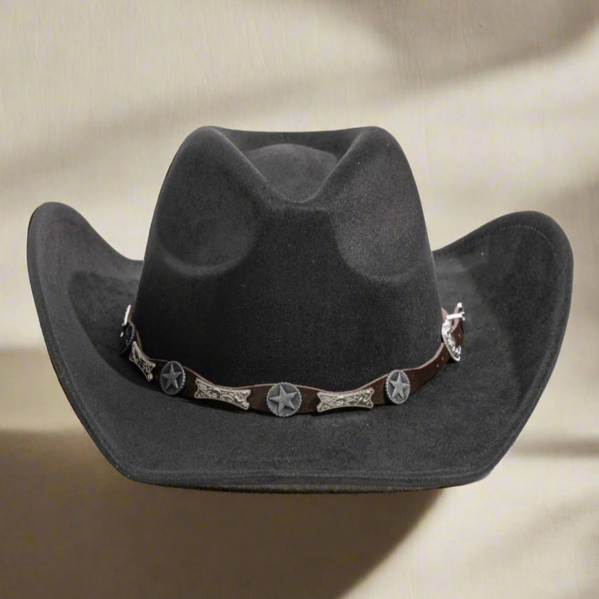 Black cowboy hat with decorative band on a brown background