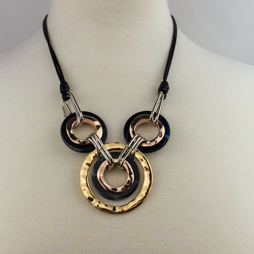 Interlocking Rings Necklace — Mixed-Tone Alloy, Black Cord, angled view of the bib on a mannequin