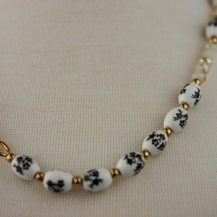 Porcelain Bead Necklace — Floral Print, Gold-Tone Ring, close-up of floral beads and champagne glass beads