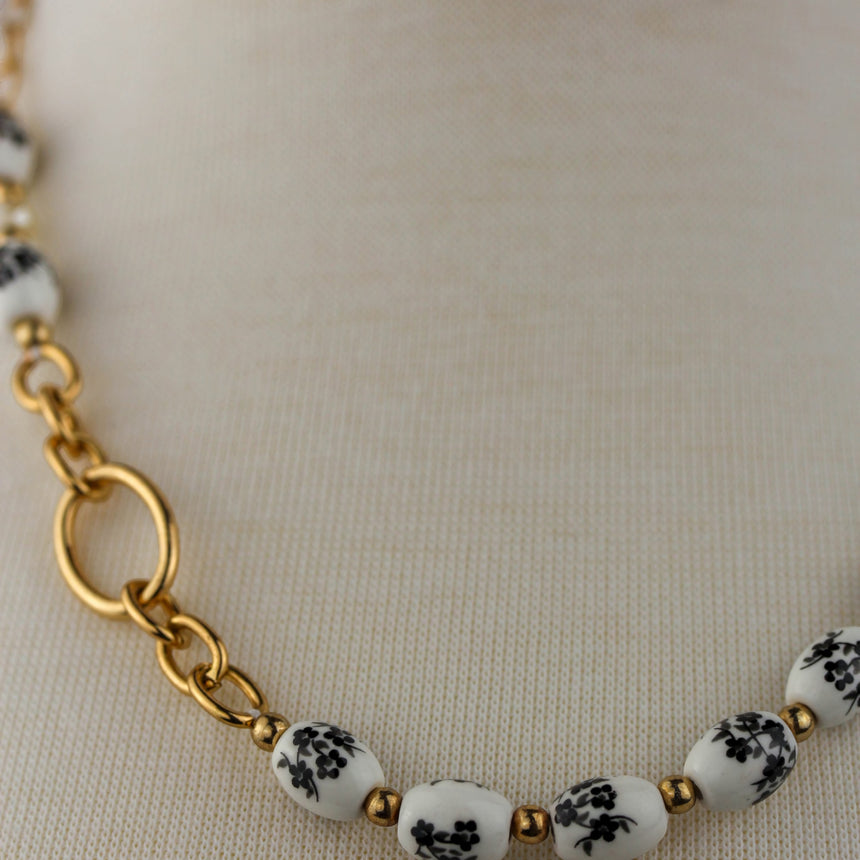 Porcelain Bead Necklace — Floral Print, Gold-Tone Ring, close-up of the gold-tone ring accent