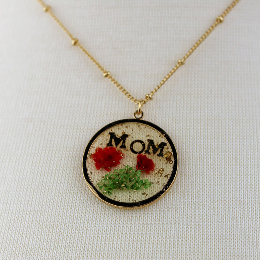 Pressed Flower Mom Pendant — Resin Disc, Gold-Tone Beaded Chain, close-up of the flowers and MOM lettering