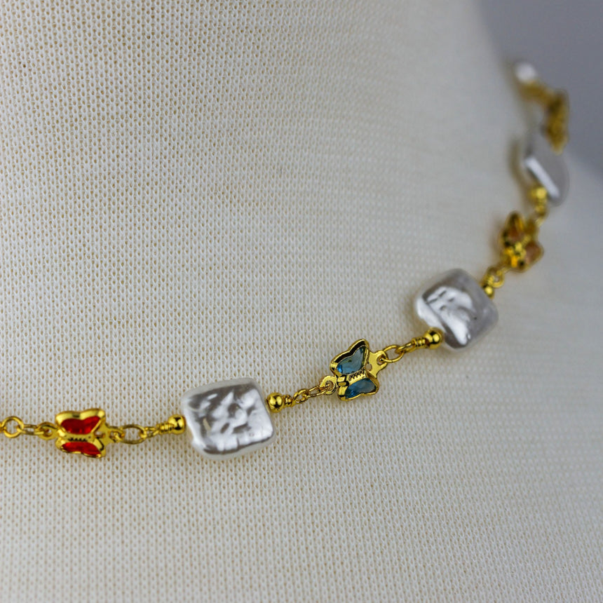 Pearl-Tile Butterfly Choker — Gold-Tone Alloy, Stations, angled close-up showing red and blue butterflies