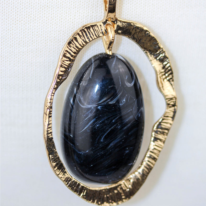 Marbled Cabochon Pendant — Hammered Gold-Tone Oval, Long Chain, close-up of the swirled cabochon and frame