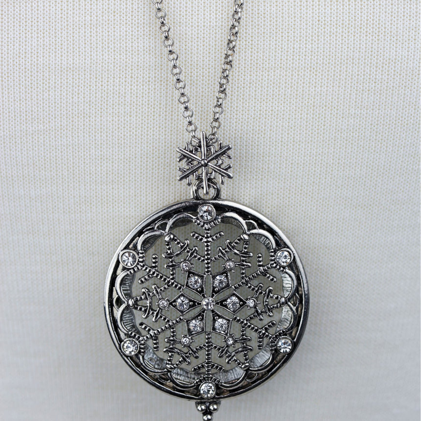 Snowflake Filigree Locket — Gunmetal-Tone Alloy, Magnifier, close-up of the snowflake filigree and rhinestones