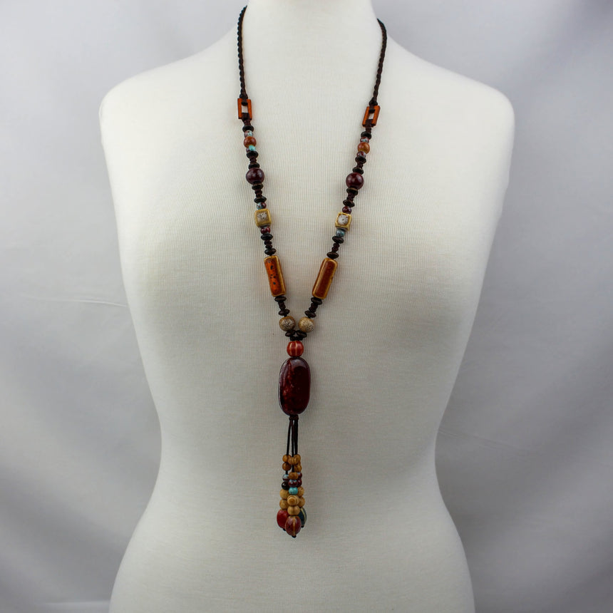Boho Y Necklace — Red Oval Focal, Mixed Beads on Brown Cord, worn full length on a mannequin