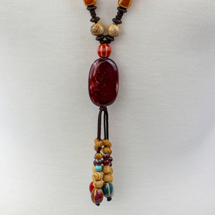 Boho Y Necklace — Red Oval Focal, Mixed Beads on Brown Cord, close-up of the red oval focal and tassel drop