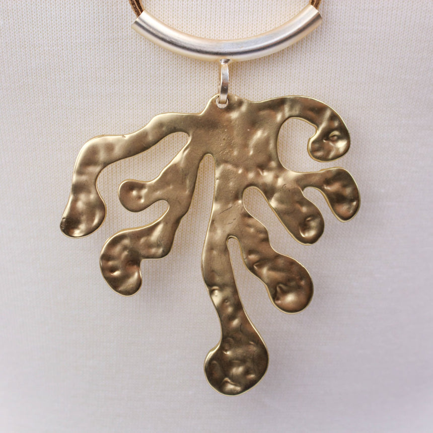 Hammered Leaf Necklace — Gold-Tone Alloy, Faux-Suede Cords, close-up of the hammered leaf pendant and curved tube bar