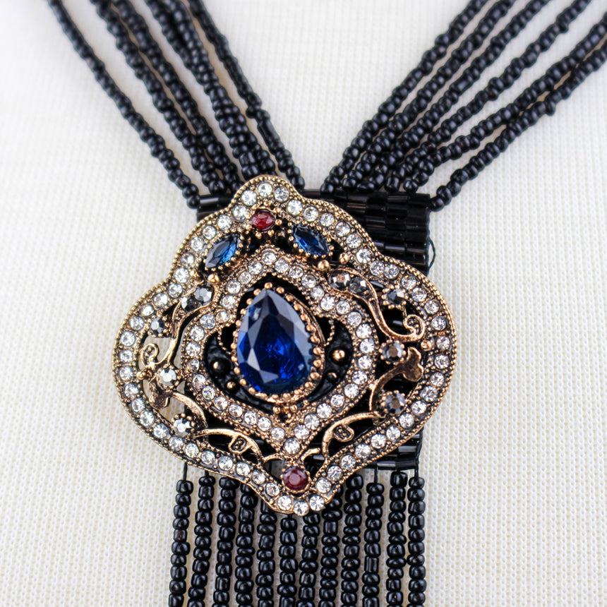 Black Fringe Y-Necklace — Seed Beads, Crystal Medallion, close-up of the medallion with blue teardrop crystal