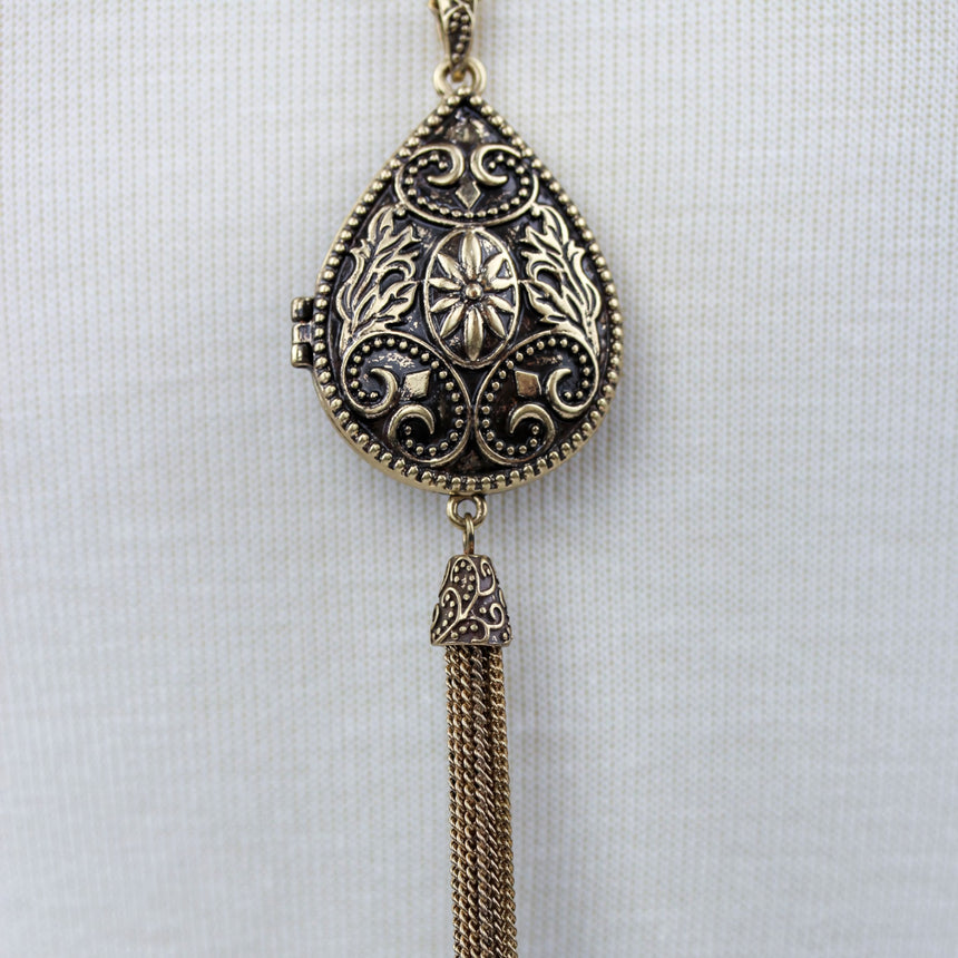 Teardrop Filigree Locket Necklace — Gold-Tone Alloy, Tassel, close-up of the closed locket front and tassel cap