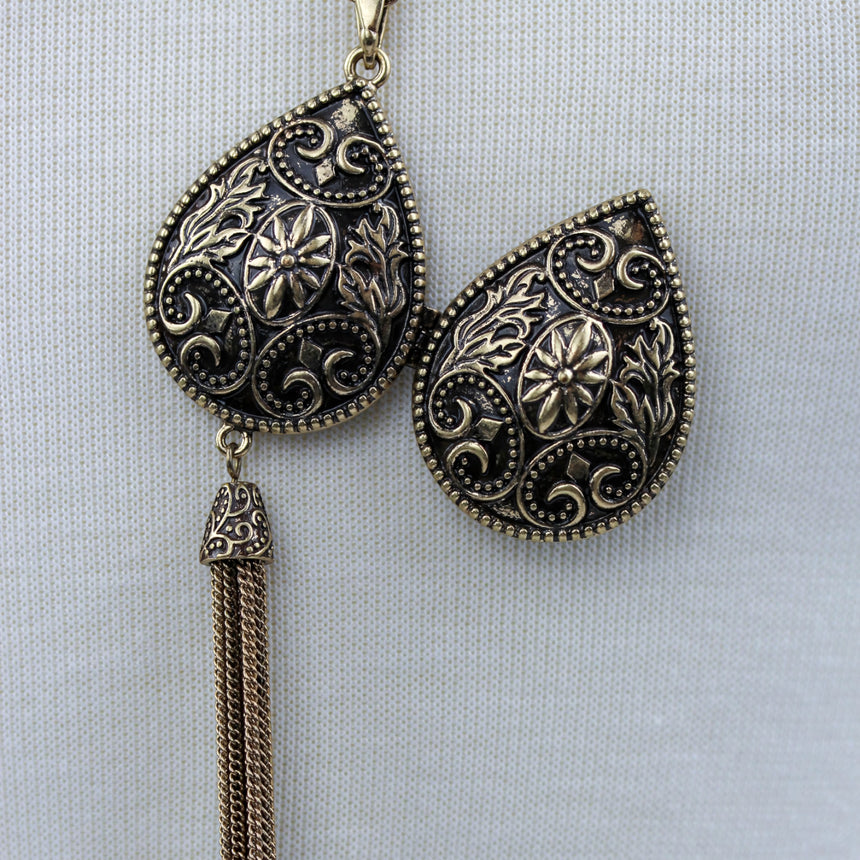 Teardrop Filigree Locket Necklace — Gold-Tone Alloy, Tassel, lid flipped open beside the locket body