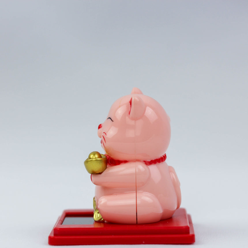 Solar Waving Fortune Cat with Gold Ingot, pink side profile facing left, gold ingot at its chest, on a red square base