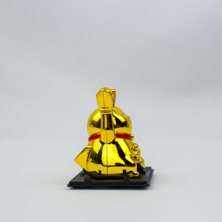 Solar Fortune Cat with Raised Ingot, gold version seen from the opposite side, red collar band, on the black tray