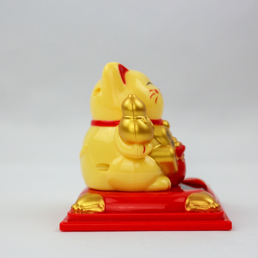 Solar Fortune Cat with Gourd and Money Bag, yellow side view showing the gourd and red bag, seated on the red pedestal