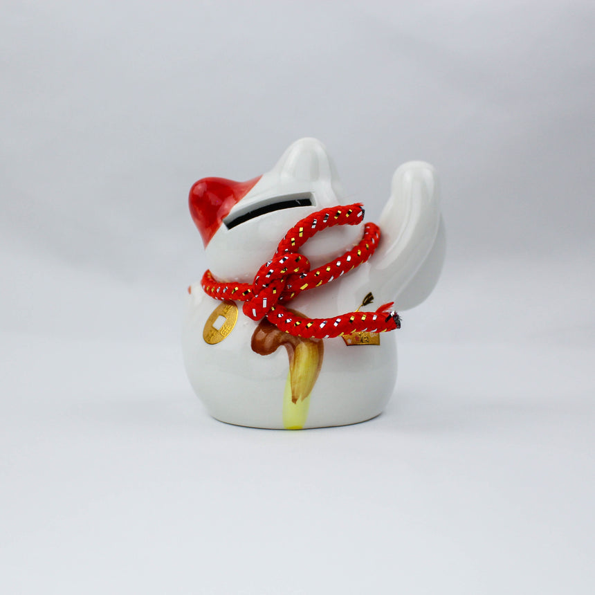 Da Ji Da Li Ceramic Lucky Cat Coin Bank, back view showing the coin slot between raised paws and a red cord bow