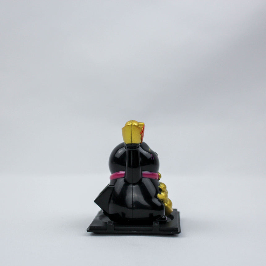 Solar Fortune Cat with Raised Ingot, black version in a distant rear angle, wide landscape shot on the black tray